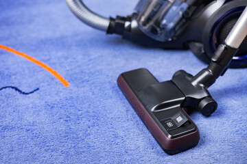 Removing dirt from beige carpet with modern vacuum cleaner
