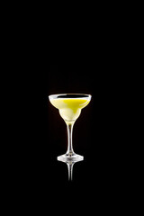 Yellow creamy cocktail in elegant glass on black reflective background. Concept of calm luxury and premium lifestyle for beverage branding and advertising visuals.