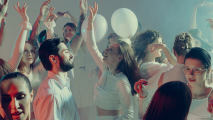 Smiling crowd dancing together in dreamy glowing white Valentine light. Concept of social celebration, emotional unity, and youthful expression of happiness.