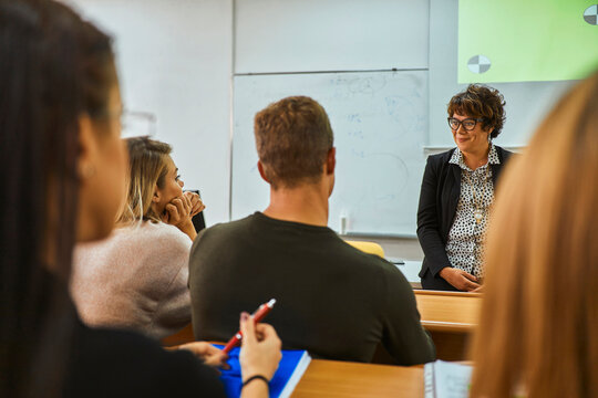Lecturer smiling at students in auditorium at university