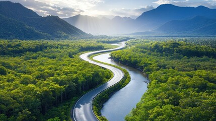 Winding road through lush green valley. Sunlight highlights mountains