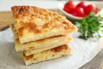 Pieces of delicious Megrelian khachapuri and products on table, closeup