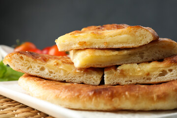 Pieces of delicious Megrelian khachapuri on table, closeup