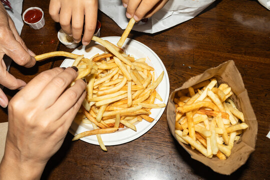 Family sharing french fries together at a table