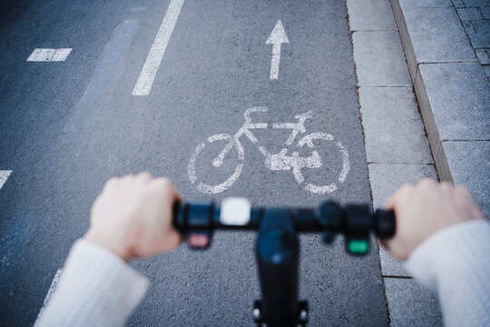 Man riding push scooter on bicycle lane