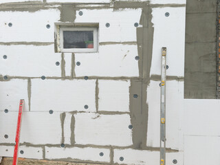 White wall insulated with polystyrene foam, with a window in the middle