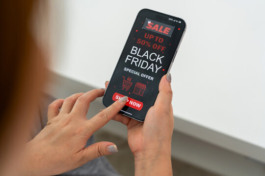 Person using mobile app shop online holding smartphone with Black Friday sale ad with up to 50% off, marketing and e-commerce promotions, holiday shopping, online deals and digital advertising