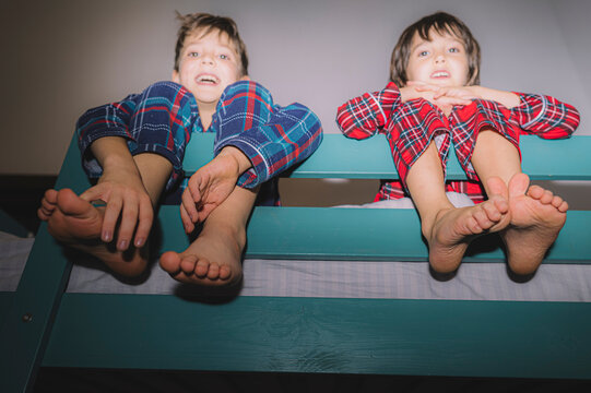 Brothers in pajamas fooling around on a bunk bed at home