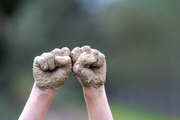 close up of kids hands with mud on it