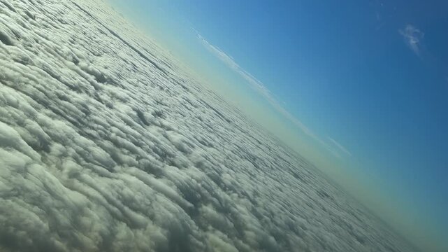 An immersive pilot&rsquo;s perspective from cockpit in an abrupt left turn over an endless sea of stratus clouds illuminated by the sunrise light. Footage taken from a jet cokpit.