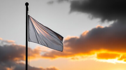 White flag waving against dramatic sunset sky with storm clouds