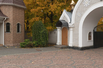 arched entrance to the monastery grounds with autumn trees