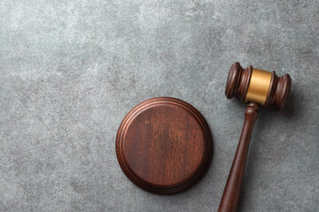 Judge gavel with sound block on a gray stone surface. Represents courtroom authority and legal...