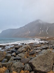 Waves of Norwegian sea surging on stone rocks at Unstad beach, Lofoten islands, Norway in winter storm. 
