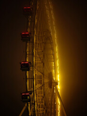 The Moscow Sun Ferris wheel in thick fog with night illumination at VDNKh Park.