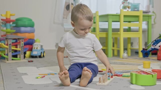 Toddler boy playing with educational wooden sorter toy