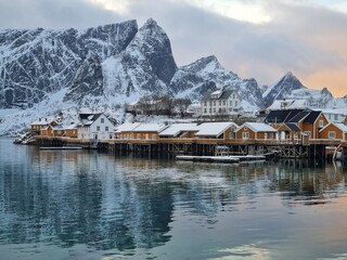 Beautiful view of scenic Lofoten Islands archipelago winter scenery with traditional yellow fisherman Rorbuer cabins in the historic village of Sakrisoy at sunrise, Norway, Scandinavia
