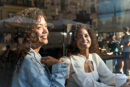 Happy women friends enjoying coffee shop window reflections - Powered by Adobe