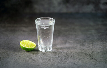 Vodka. Shots, glasses with vodka with ice and lime on gray background