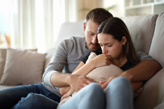 Sad couple complaining together at home