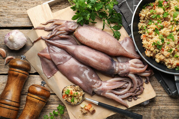 Raw squids, stuffing and parsley on wooden table, flat lay