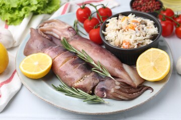 Raw squids, stuffing, rosemary, lemon and tomatoes on white table, closeup