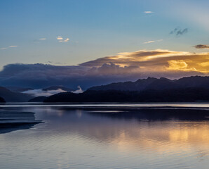 Morning light and low mist over the Mawddach Estuary with reflections on calm water