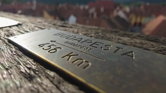 Close-up of a brass plate indicating the distance to Budapest, Hungary from the Clock Tower in Sighișoara, Romania.