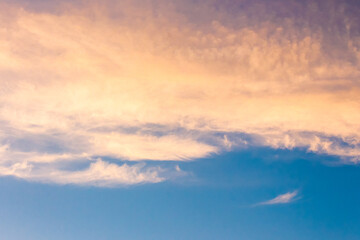 orange cloud on blue sky at sunset. beautiful nature background at dusk for meteorology. cloudscape in yellow light. abstract scene of summer weather