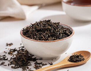 Organic loose leaf black tea in ceramic bowl with copy space for wellness concept
