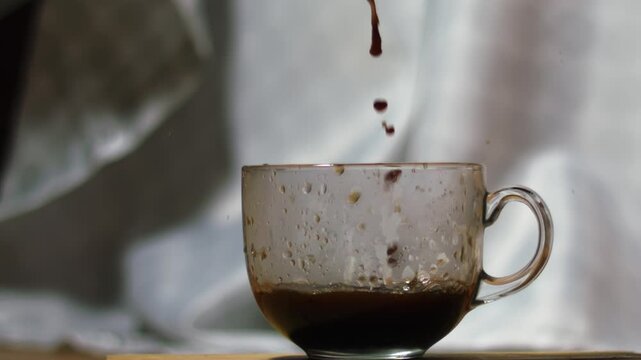 Pouring coffee into into a glass mug