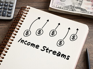 Income streams increasing shown on notebook with calculator and us dollars
