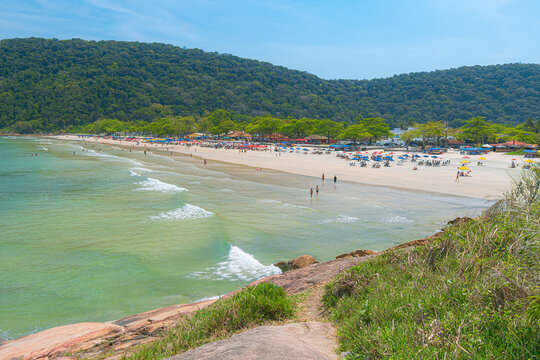 Guaiuba Beach, Guaruja SP, Brazil. Sunny day over the small bay with tranquil sea. Image of leisure and tourism on the Sao Paulo coast. Hills covered in Mata Atlantica vegetation frame the view.