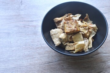 fried slice yellow tofu and gypsum with celery in soy sauce vegetarian food on bowl