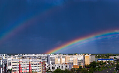 Fantastic beautiful rainbow over city buildings after rain