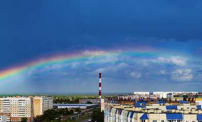 Fantastic beautiful rainbow over city buildings after rain