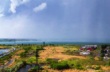 Heavy rainfall over countryside near lake