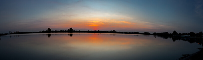 Panoramic view on sunset over lake