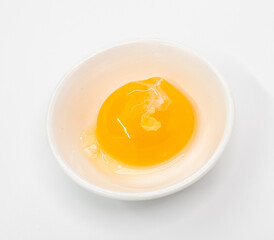 Bright Raw Egg in White Bowl On White Studio Background, Fresh Breakfast Ingredient Photography