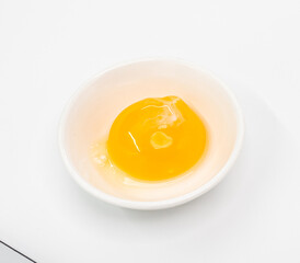 Bright Raw Egg in White Bowl On White Studio Background, Fresh Breakfast Ingredient Photography