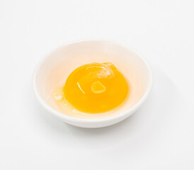 Bright Raw Egg in White Bowl On White Studio Background, Fresh Breakfast Ingredient Photography