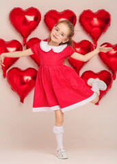 Happy girl in red polka-dot dress poses with heart balloons.
Studio photo captures Valentine mood and playful energy.
Cheerful portrait shows childhood joy and festive style.

