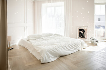 Bright minimalist bedroom with white bedding and natural light.
Wooden herringbone floor adds warmth to modern Scandinavian design.
Peaceful interior creates cozy atmosphere and elegant simplicity.
