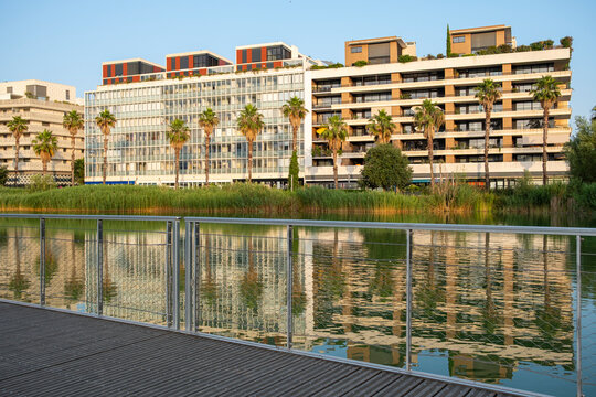 Reflective modern apartments facing a calm lake in Montpellier, combining sustainable architecture with nature, sunlight, and serene urban balance
