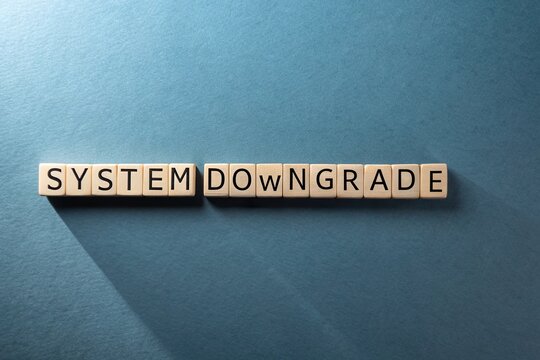 Scrabble Tiles Spelling System Downgrade on Blue Grey Surface - Powered by Adobe
