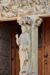 Close-up of religious sculptures on the facade of Notre Dame in Paris with stone-carved figures and Gothic architecture