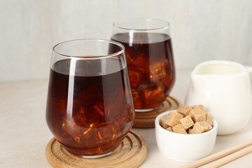 Tasty iced coffee, milk and sugar on white table, closeup