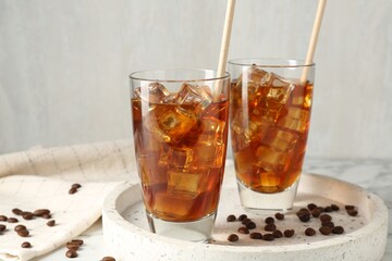 Tasty iced coffee and beans on table, closeup