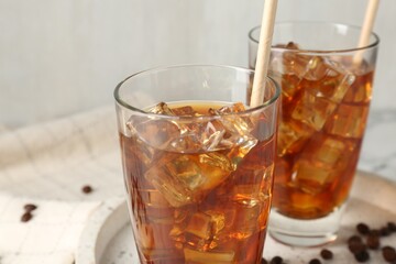 Tasty iced coffee and beans on table, closeup