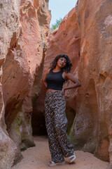 A woman is posing in a cave with her back to the camera